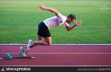 Sprinter leaving starting blocks on the running track. Explosive start.