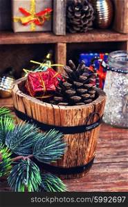 Spruce branch,wooden bucket with heater and gifts on the background of Christmas decorations