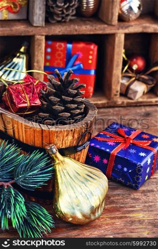 Spruce branch,wooden bucket with heater and gifts on the background of Christmas decorations