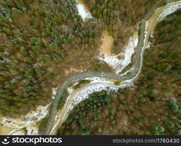 Spruce forest in the beginning of winter. Little river. A snow on the ground. Top view vertically down. River and Snow in the Spruce Forest. Aerial View
