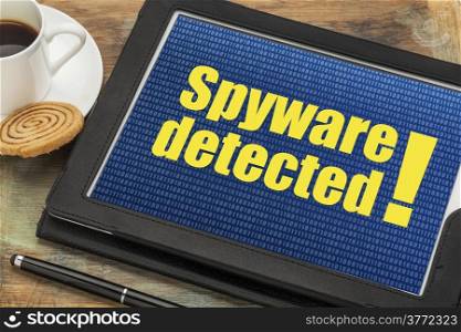 spyware detected alert on a digital tablet with a cup of coffee