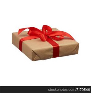 square box wrapped in brown kraft paper and tied with a silk red ribbon, side view, gift isolated on a white background