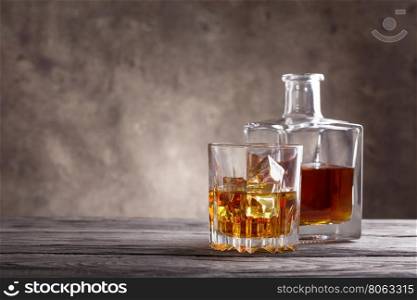 Square decanter and glass of whiskey on wooden table. Square decanter and glass of whiskey