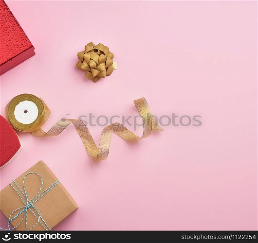 square gift boxes decorated with ribbons and bows on a pink background, top view, place for text