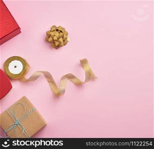 square gift boxes decorated with ribbons and bows on a pink background, top view, place for text