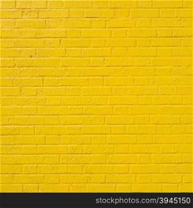 square part of bright yellow painted brick wall