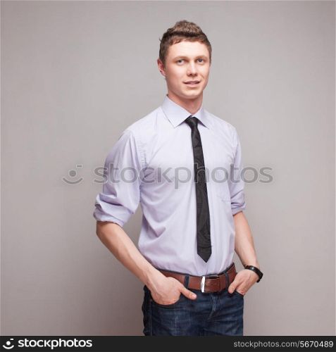 square portrait of cheerful young man in blue shirt with tie and jeans