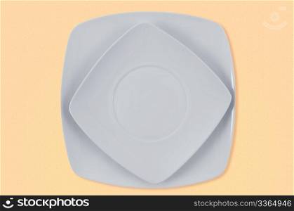Square white plates on yellow background.