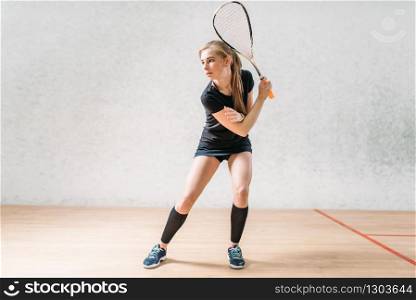 Squash game training, female player with racket in hands, indoor sport club on background. Squash game training, female player with racket