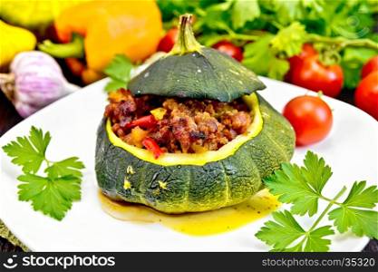 Squash green stuffed with meat, tomatoes and peppers in the dish, garlic and parsley on a wooden board background