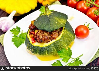 Squash green stuffed with meat, tomatoes and peppers on a napkin, garlic and parsley on a wooden board background