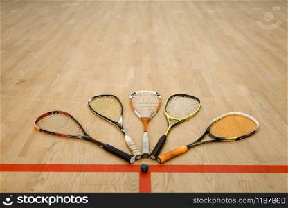 Squash rackets and ball on court floor, nobody. Active sport hobby, fitness workout for healthy lifestyle. Squash rackets and ball on court floor, nobody