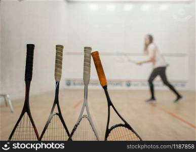 Squash rackets, female player on court on background. Girl on game training, active sport hobby on court, fitness workout for healthy lifestyle. Squash rackets, female player on background