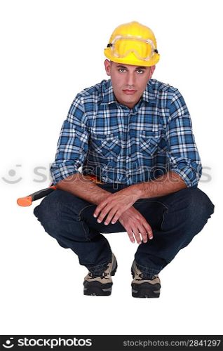 Squatting tradesman with a piercing stare