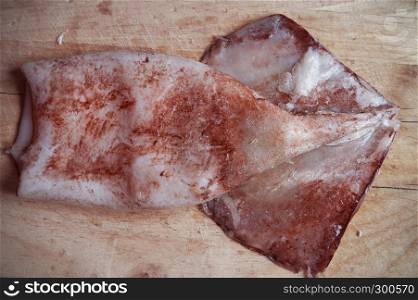 squid meat on wooden cutting board