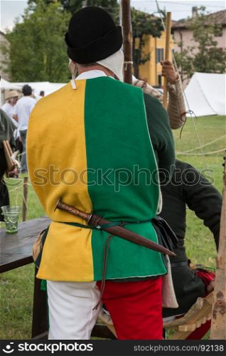 Squire with Black Hat, Two-coloured Shirt and Dagger in his Belt during Medieval Event Reconstruction
