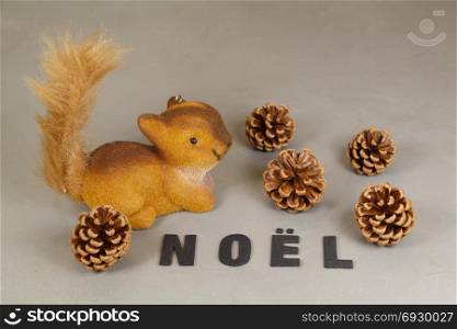 Squirrel figurine, pine cones and the word Christmas in french