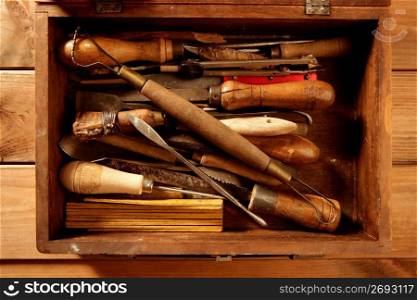 srtist hand tools for handcraft works on golden wood background