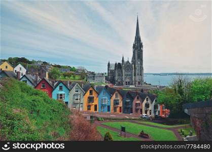 St. Colman&rsquo;s Cathedral And Colored Houses In Cobh, Ireland in Summer