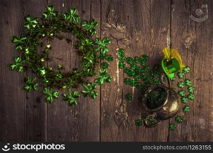 St. Patricks Day composition. Shamrock wreath, shamrocks and silver pot on an old rustic wood background. St.Patrick&rsquo;s day holiday symbol. Top view, copy space.