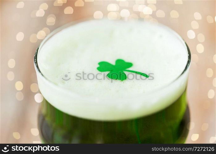 st patricks day, holidays and celebration concept - close up of glass of green draft beer with shamrock. close up of glass of green beer with shamrock