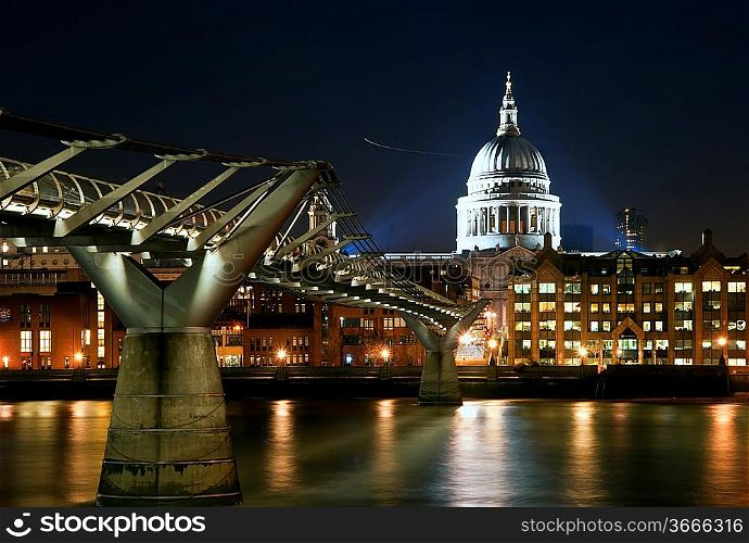 St Paul&acute;s Cathedral and Millennium Bridge in London at night with reflections in River Thames with vibrant colors and floodlights