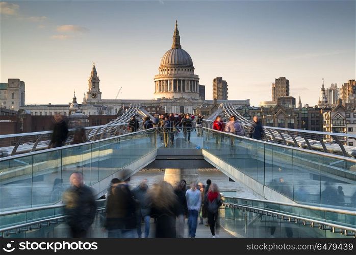 St Pauls Cathedral and the Millennium Bridge landscape with blur. England, London, City of London. St Pauls Cathedral and the Millennium Bridge at sunset.. St Pauls Cathedral and the Millennium Bridge at sunset landscape with blurred tourists