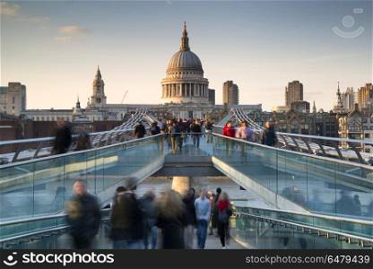 St Pauls Cathedral and the Millennium Bridge landscape with blur. England, London, City of London. St Pauls Cathedral and the Millennium Bridge at sunset.. St Pauls Cathedral and the Millennium Bridge at sunset landscape with blurred tourists