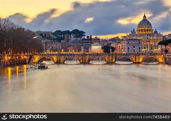 St. Peter&rsquo;s cathedral and Tiber river with high water at evening with dramatic sunset sky. Saint Peter Basilica in Vatican city with Saint Angelo Bridge in Rome, Italy