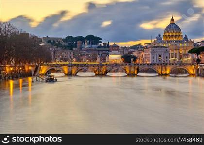 St. Peter&rsquo;s cathedral and Tiber river with high water at evening with dramatic sunset sky. Saint Peter Basilica in Vatican city with Saint Angelo Bridge in Rome, Italy