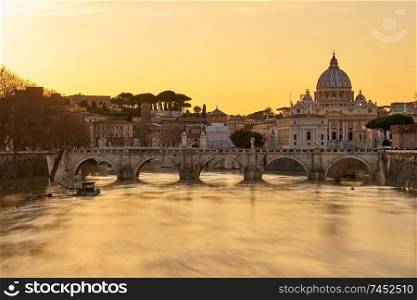 St. Peter&rsquo;s cathedral and Tiber river with high water at  sunset. Saint Peter Basilica in Vatican city with Saint Angelo Bridge in Rome, Italy