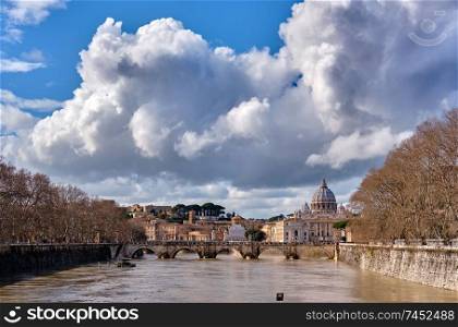 St. Peter’s cathedral and Tiber river with high water in February. Saint Peter Basilica in Vatican city with Saint Angelo Bridge in Rome, Italy