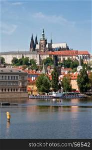 St. Vitus Cathedral on the hill, district Hradcany, Vltava river and ships at berth. Prague