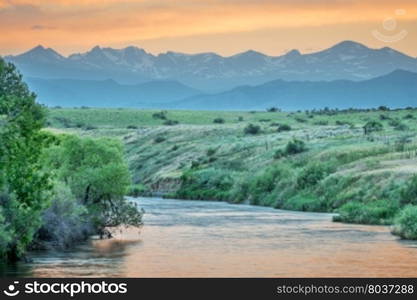 St Vrain Creek and Front Range of Rocky Mountains at dusk, St Vrain State Park near Longmont, Colorado