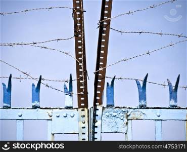 Stacheldraht-Zacken. old rusty barbed wire on a blue screen door