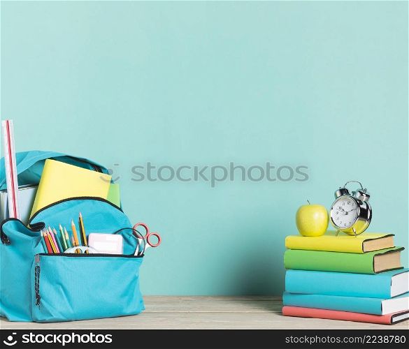 stack books alarm clock school backpack with supplies