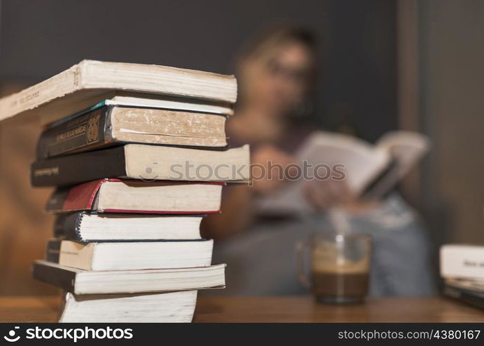 stack books near reading woman coffee