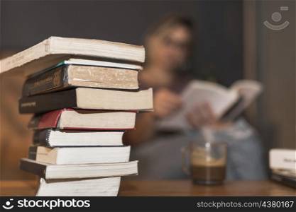 stack books near reading woman coffee