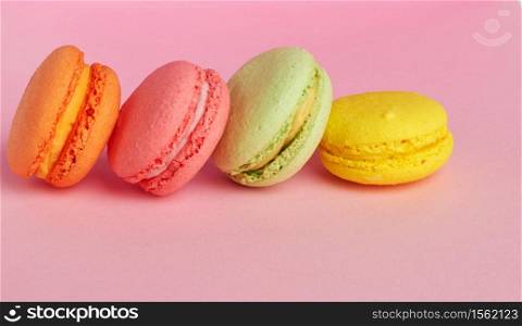 stack of baked macarons on pink background, delicious dessert made from almond flour, close up
