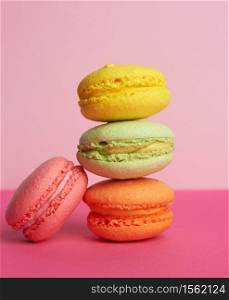 stack of baked macarons on pink background, delicious dessert made from almond flour, close up