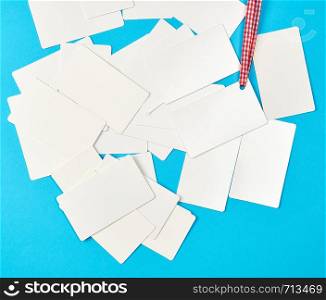 stack of blank rectangular paper white business cards on a blue background, top view