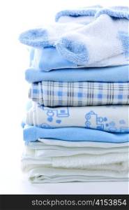 Stack of blue infant clothing for baby shower
