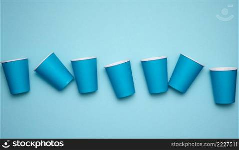 stack of blue paper cups on a blue background. Plastic rejection concept, zero waste, top view