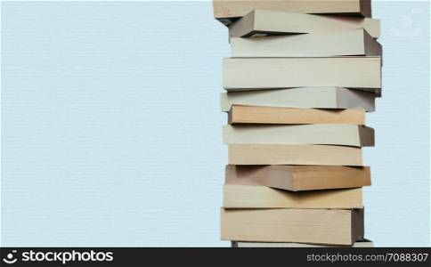 Stack of books before blue background