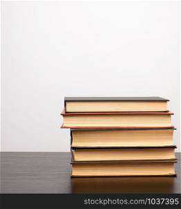 stack of books on a black table, white background, copy space