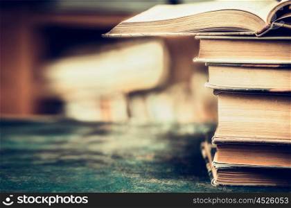 Stack of books on aged table, close up, place for text, retro styled