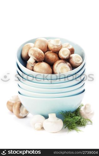 Stack of bowls and Fresh mushrooms over white