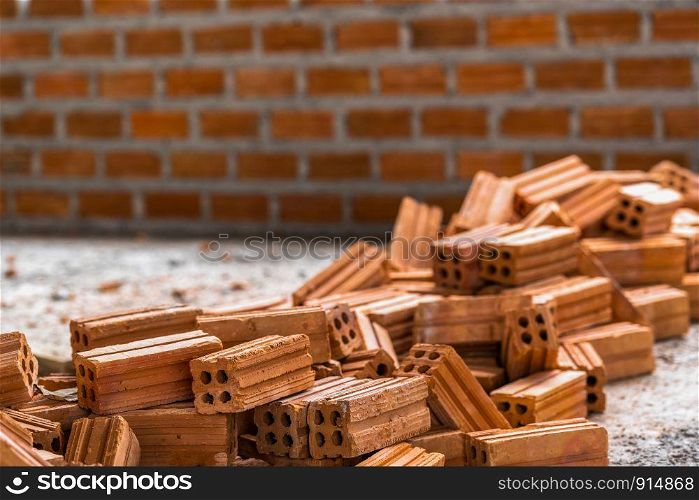 Stack of Brick preparing for mansonry over the photo blurred of Bricks wall background,
