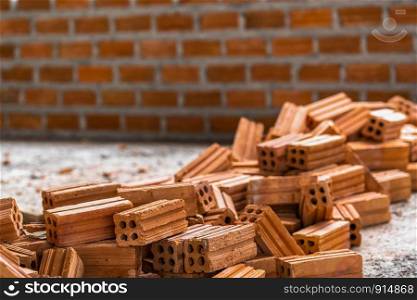 Stack of Brick preparing for mansonry over the photo blurred of Bricks wall background,