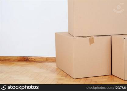 Stack of cardboard boxes in the empty room with copy space. Move concept. Stack of cardboard boxes in the empty room